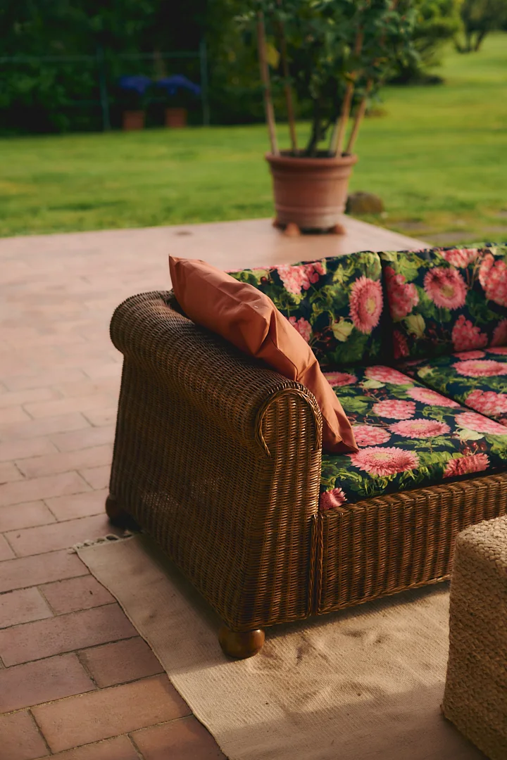 Floral outdoor sofa as a styling backdrop at Villa Niccolai