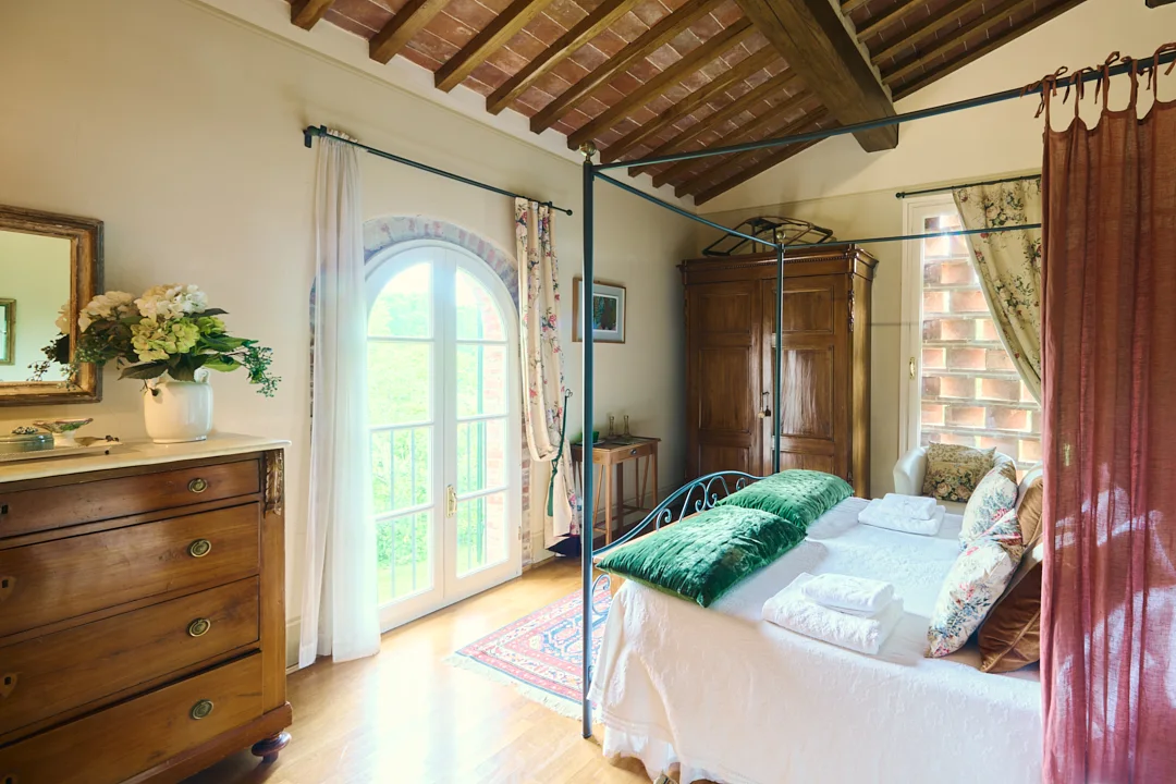 Green bedroom with a four-poster bed at Villa Niccolai