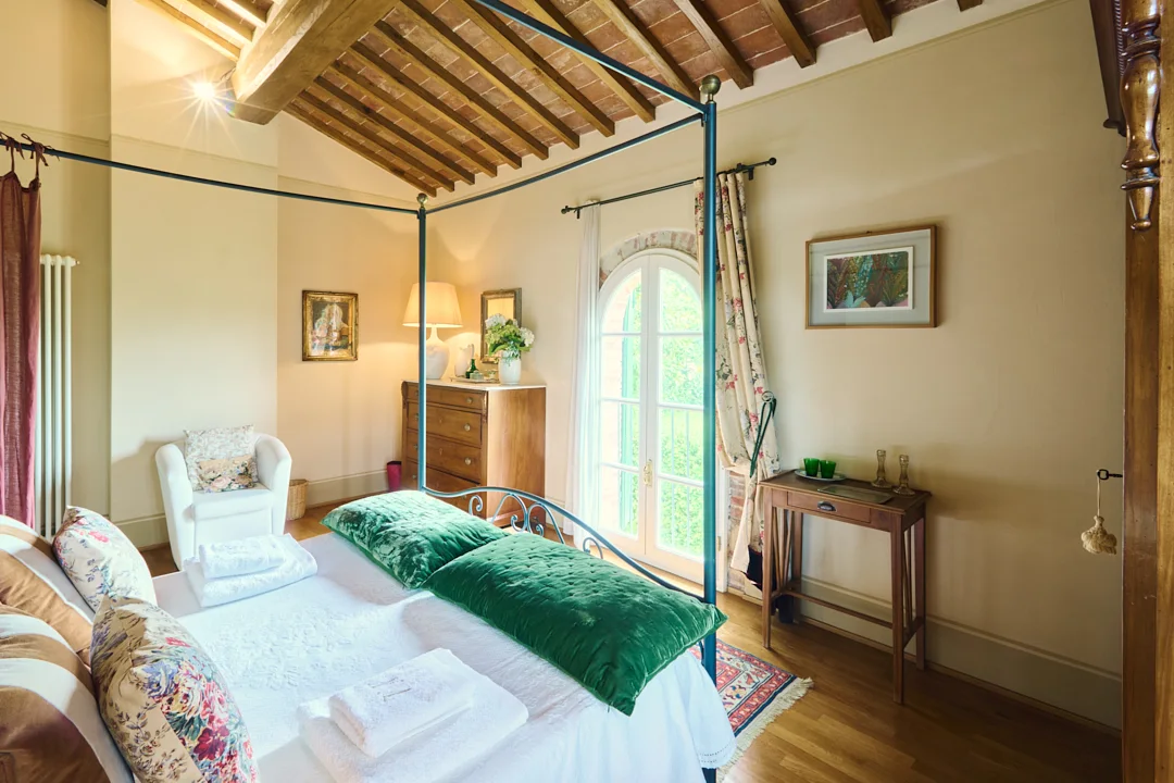 Four-poster bedroom overlooking the garden at Villa Niccolai