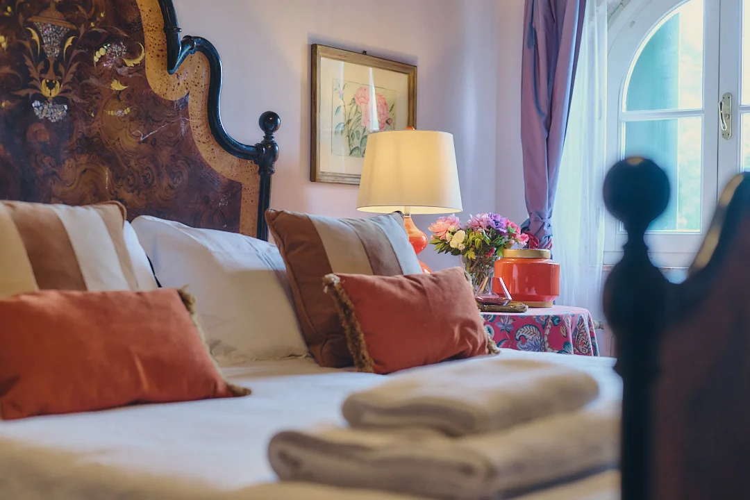 Antique bed and decorative details in a Villa Niccolai bedroom