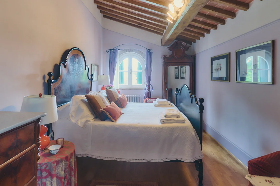 Pink bedroom with antique furniture at Villa Niccolai