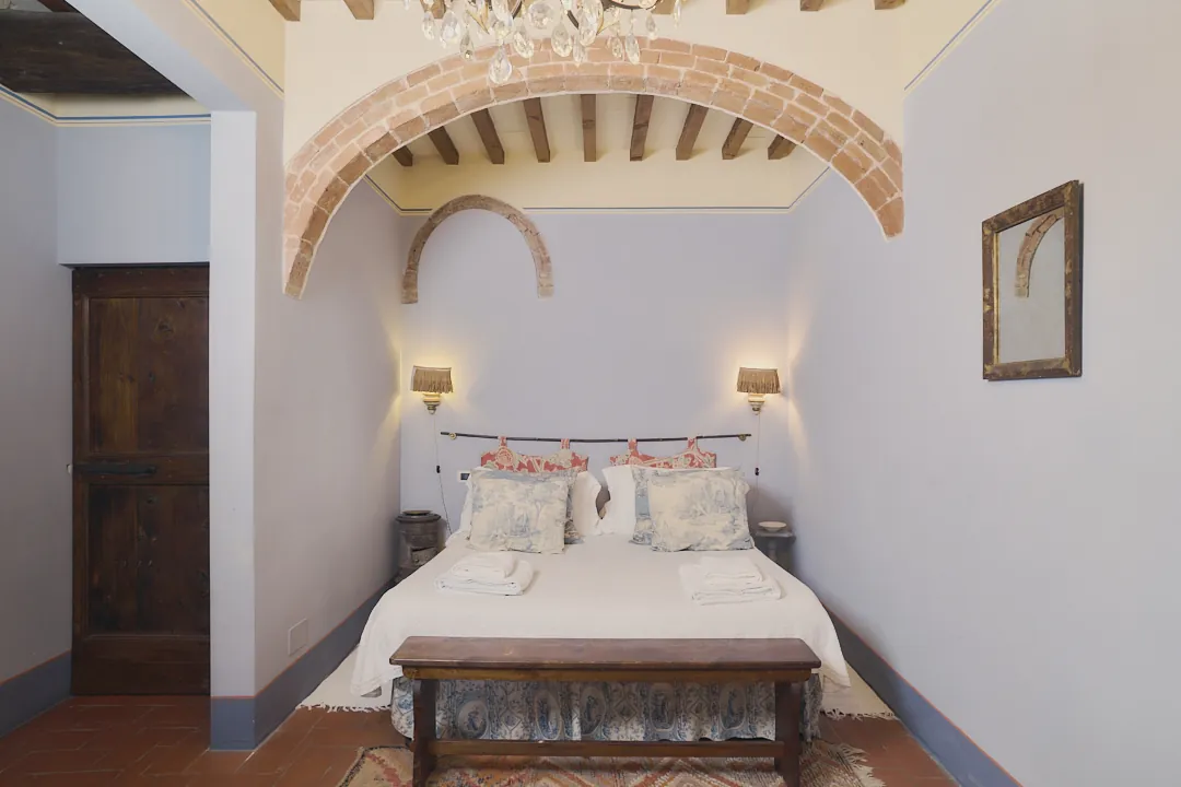 Bedroom with historic brick arches at Villa Niccolai