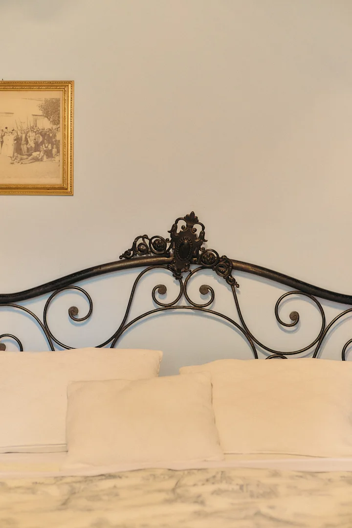 Wrought-iron bed in a historic bedroom at Villa Niccolai